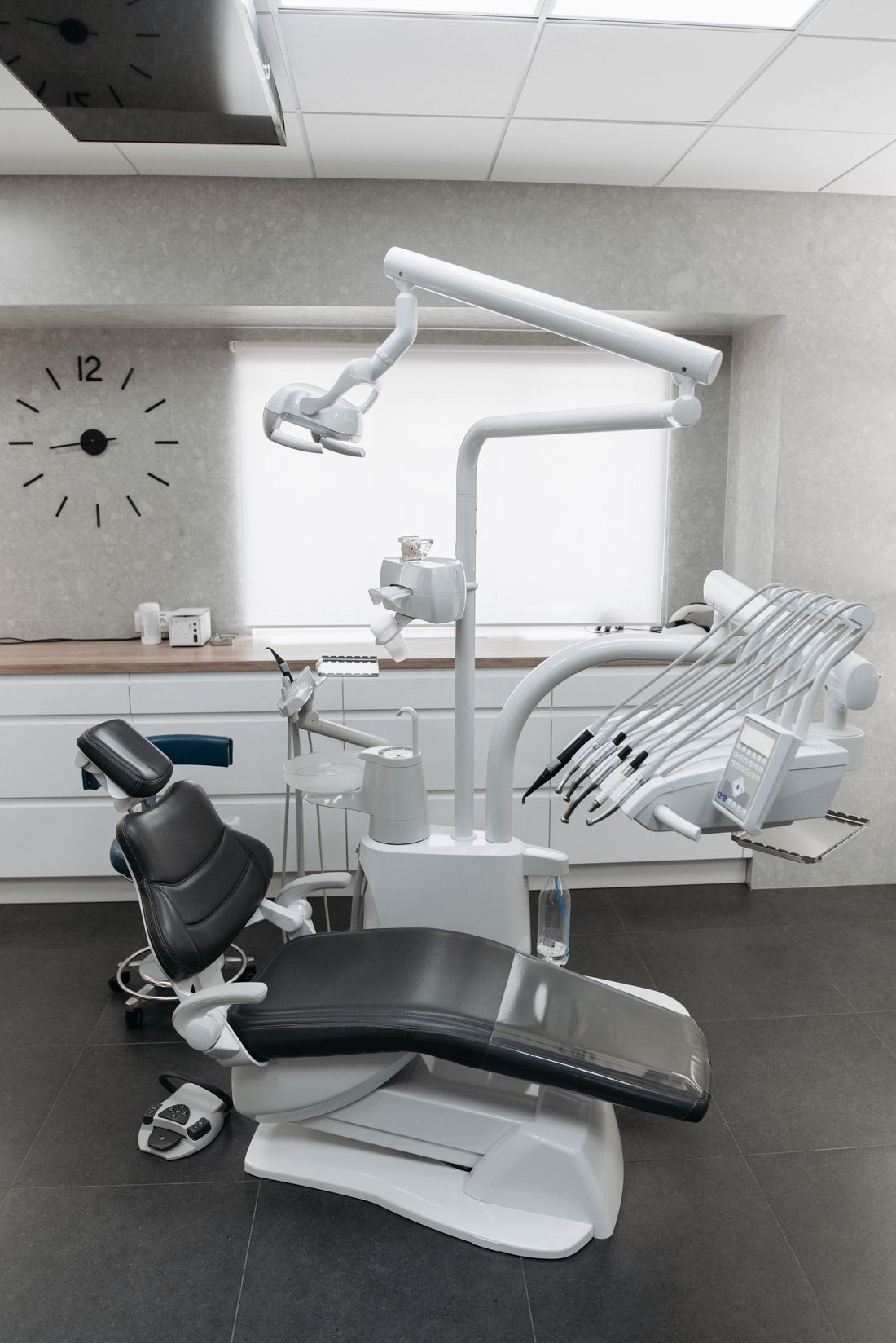 Dental chair, overhead examination light, and treatment equipment in a bright operatory